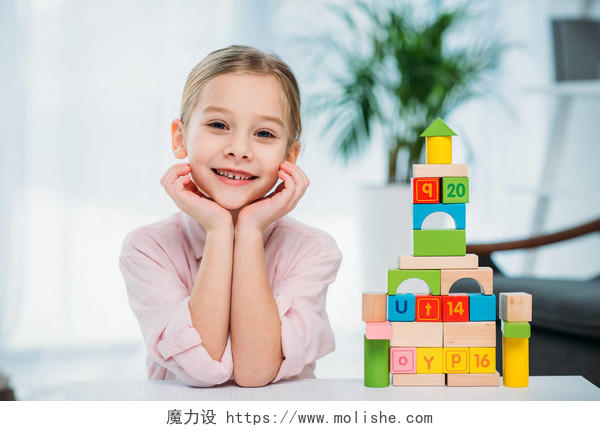 桌上彩色方块的金字塔附近的微笑的孩子